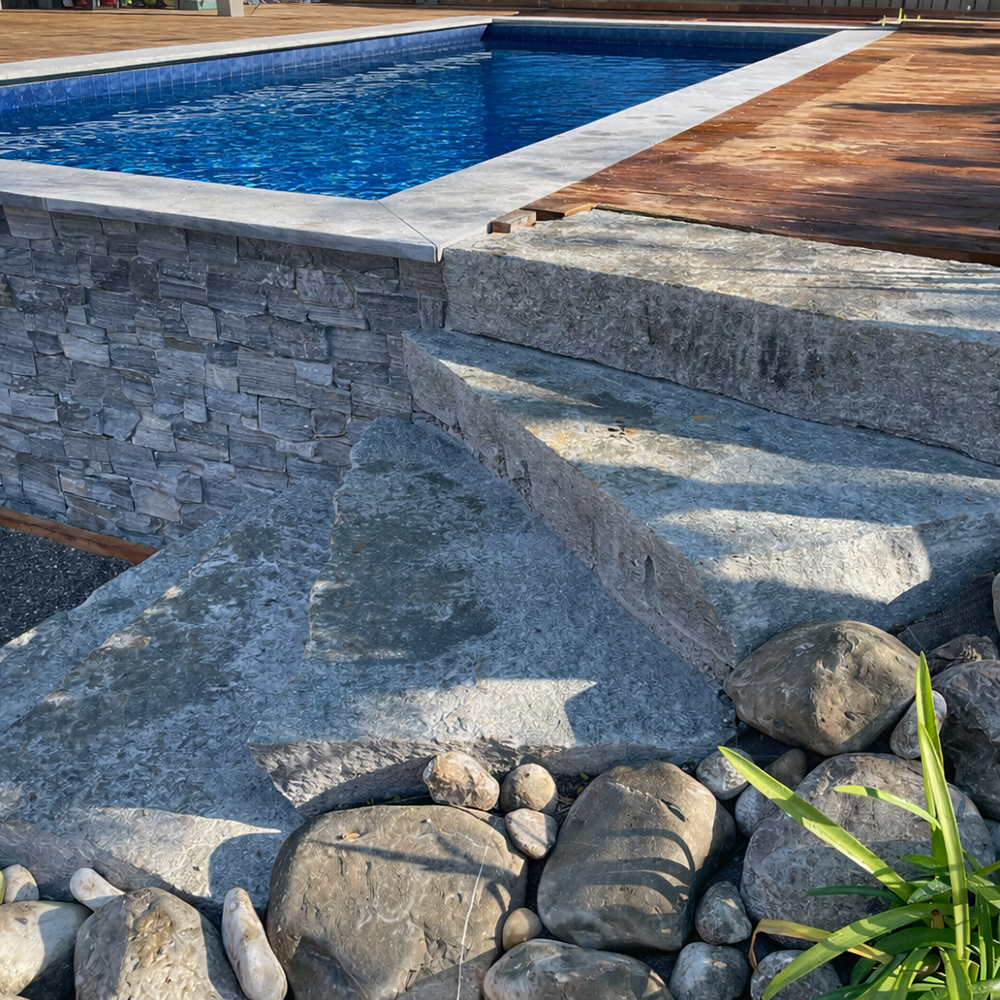 Piscine rectangulaire avec mur de soutènement en pierre avec terrasse en bois naturelle, OMH Argonay