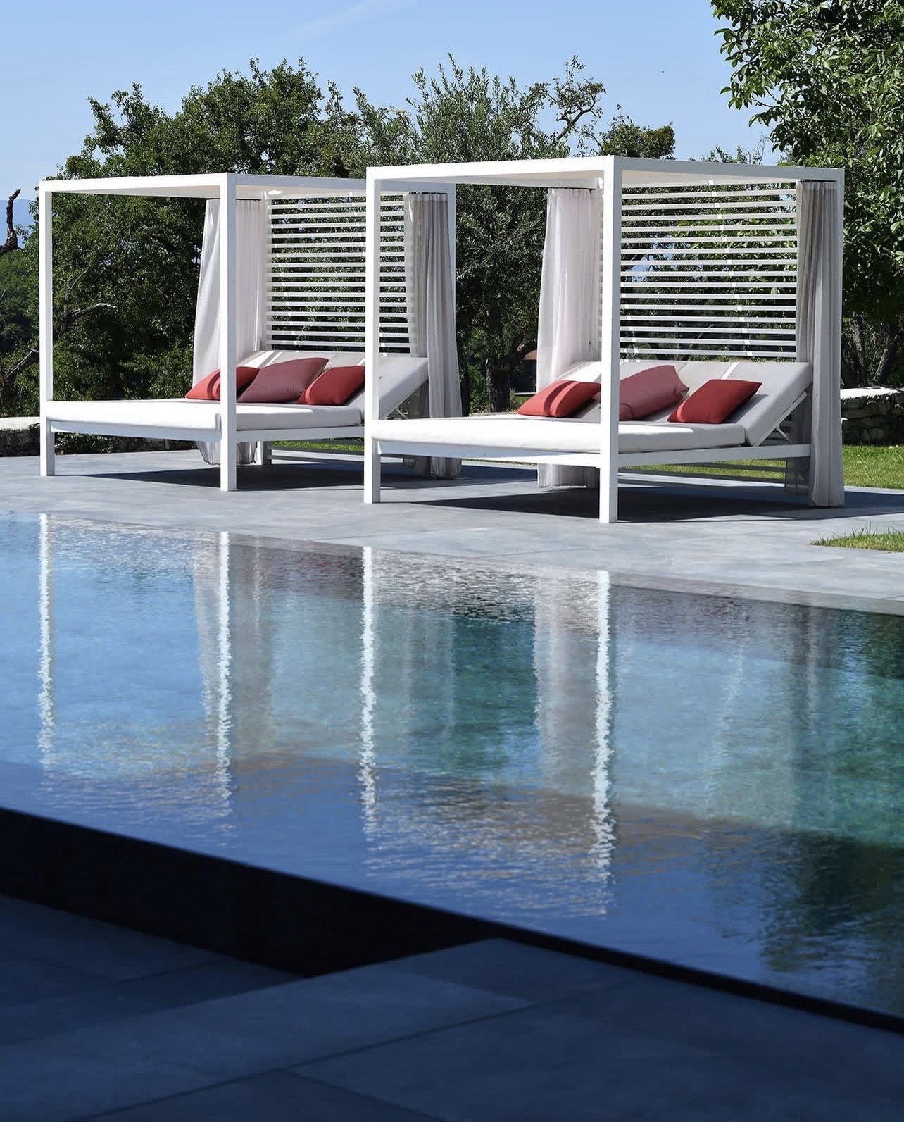 Piscine miroir sur mesure avec terrasse et chaises longues, OMH Argonay